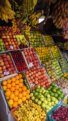 fruits of different varieties, colors and sizes kept for sale in a fruit vendor stall in the market