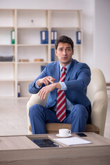 Young male employee sitting in the office