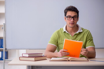 Young male student sitting in the classroom