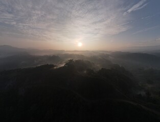 Obraz premium Aerial view of foggy forest landscape in Indonesia at sunrise.