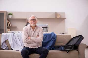 Old man preparing for trip at home