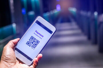 Selective focus to hand holding smartphone with payment display qr code.