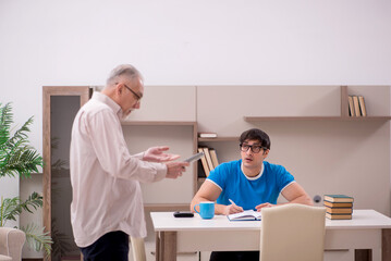 Young male student and his grandfather at home