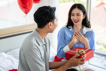 Beautiful young couple surprise with rose and gift in bedroom,Valentine's Day  concept.