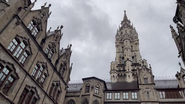 Labyrinth Rathaus towering column in Marienplatz on rainy day in Munich city. Classic German architecture, famous landmark concepts