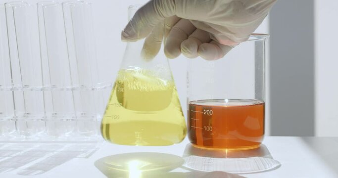 Scientist shakes a flask of motor oil in a lab 
