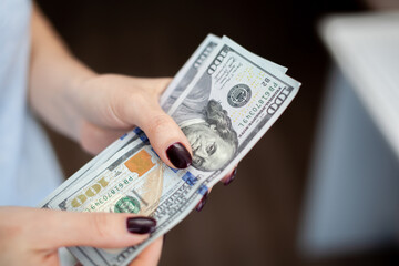 Close up female hand Counting and holding money us dollar. The concept of financial business and crisis.