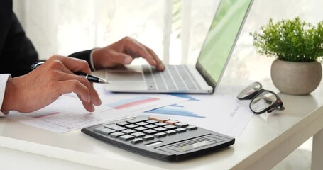 Close up business man hands using calculator counting tax financial bill. Man hands calculating number, data, graph, chart audit planning accountancy on business report. Tax audit Finacial concept.