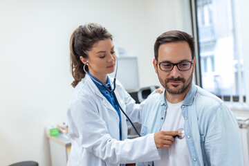 Young female doctor listen to male patient heart chest with stethoscope at clinic meeting. Woman GP checkup examine man client with phonendoscope. healthcare concept.