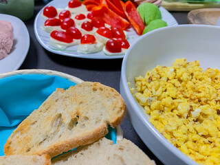 Chopped vegetables, mozzarella cheese, sausage, bread. Fried eggs.