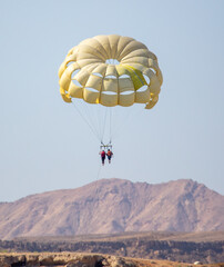 A yellow parachute flies in the sky