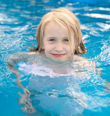 Fototapeta na wymiar Joyful child at edge of swimming pool in summer 