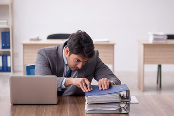 Fototapeta premium Young male employee working in the office
