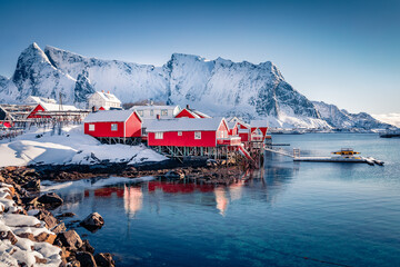 Red wooden houses on the shore of Norwegian sea. Attractive morning scene of popular tourist...