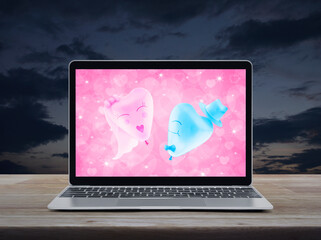 Bride and Groom love heart balloon over pink love heart screen on modern laptop computer monitor on wooden table over sunset sky, Business internet dating online, Valentines day concept