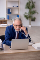 Old male employee working in the office