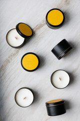 Group of wax candles in a tin box view from above against a background of marble. 