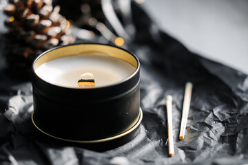 Soy scented candles in metal tins, boxes. Candles on the table in the room with a backdrop of...
