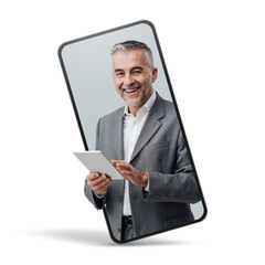 Cheerful confident businessman holding a digital tablet  in a smartphone videocall and smiling,...