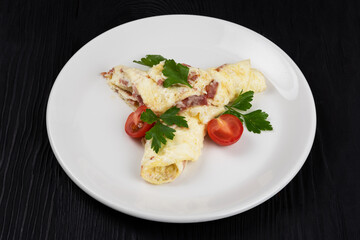 Omelet with Ham and Cheese on black wooden background