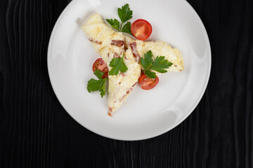 Omelet with Ham and Cheese on black wooden background