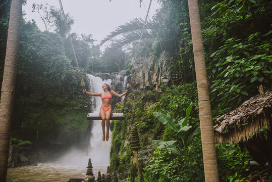 Beautiful girl having fun at the waterfalls in Bali. Concept about wanderlust traveling and wilderness culture