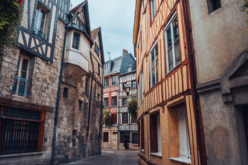 Pretty curved street in the old town of Rouen in Normandy, France with its half-timbered houses. - obrazy, fototapety, plakaty