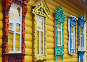 Multicolored carved wooden frames on the windows on the house