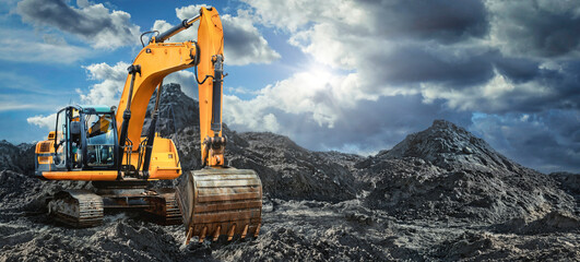 A large yellow excavator moving stone or soil in a quarry. Heavy construction hydraulic equipment....