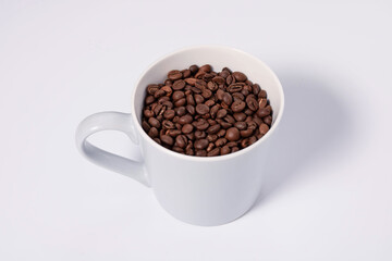 top view photo of mug full of coffee beans on white background