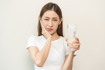 Suffering from toothache, asian young woman, girl touch cheek, face expression ache or feel pain, sensitive molar teeth, hand holding glass of water with ice, inflammation when drink cold, healthcare.