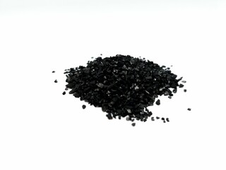 Coconut charcoal activated carbon powder pellets for water purification filter treatment, pile isolated on white background