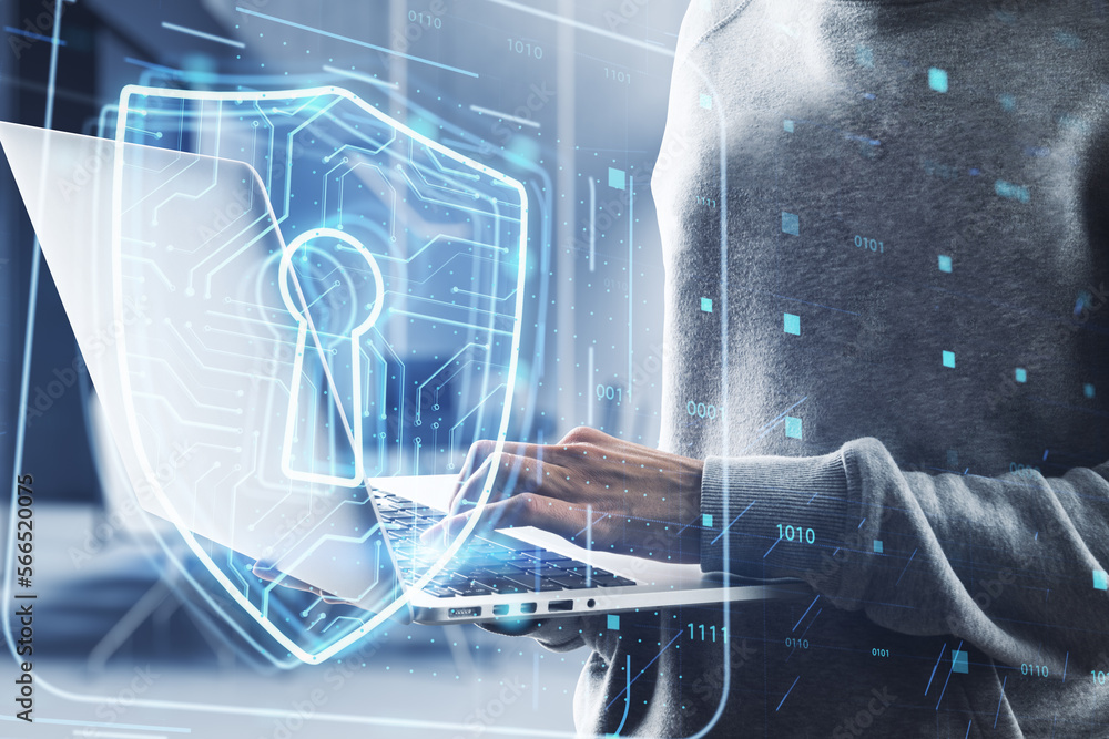 Poster close up of hacker hands using laptop with glowing padlock hologram on blurry office interior backgr