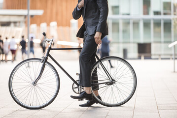 Young handsome man with business suit driving bicicyle to go to office - Corporate businessman...