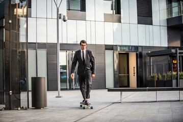 Young handsome man with business suit riding on a longboard - Corporate businessman portrait, concepts about business, mobility and lifestyle