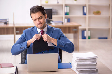 Young male employee and too much work in the office