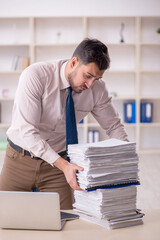 Young male employee unhappy with excessive work in the office