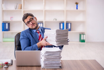 Young male employee unhappy with excessive work in the office