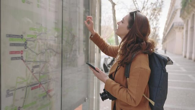 Young tourist woman checking map on cell phone looking for bus direction on public transport