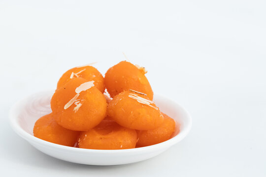 Indian Bengali Mithai Orange Kheer Mohan Also Called Khira Mohan, Santre Ki Kheer, Or Santra Khir Mohan Is Orange Color Softball made of Chena Balls, Paneer, Doodh, Panir, Chhena Soaked In Sugar Syrup