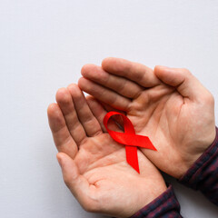 man holding a symbol of World AIDS Day