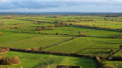 Fototapeta na wymiar Rural English countryside landscape view of green agriculture farmland fields of the Somerset Levels in Glastonbury, Somerset, England