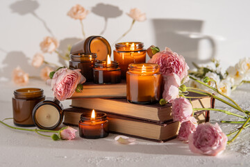 Fototapeta na wymiar A set of different aroma candles in brown glass jars. Scented handmade candle. Soy candles are burning in a jar. Aromatherapy and relax in spa and home. Fire in brown jar.