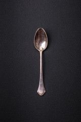 Empty metal spoon on dark textured concrete background