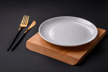 Empty ceramic round plate on dark textured concrete background