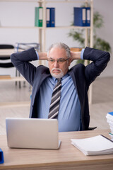 Fototapeta premium Old male employee working in the office