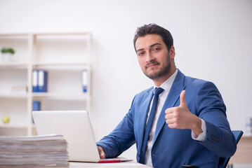 Young male employee and too much work in the office