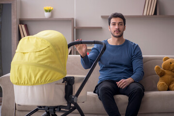 Young male contractor looking after baby at home