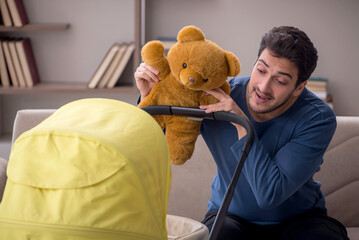 Young male contractor looking after baby at home