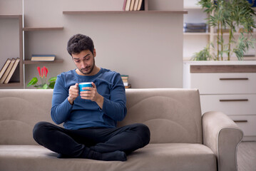 Young man drinking tea at home